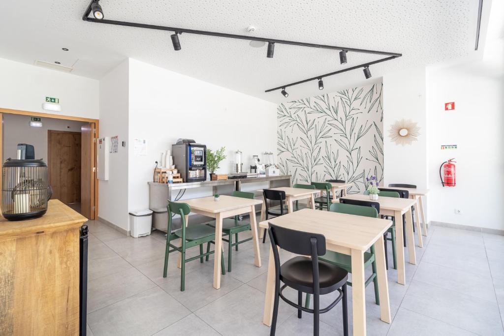 a restaurant with tables and chairs and a counter at Roots Hotel in Faro