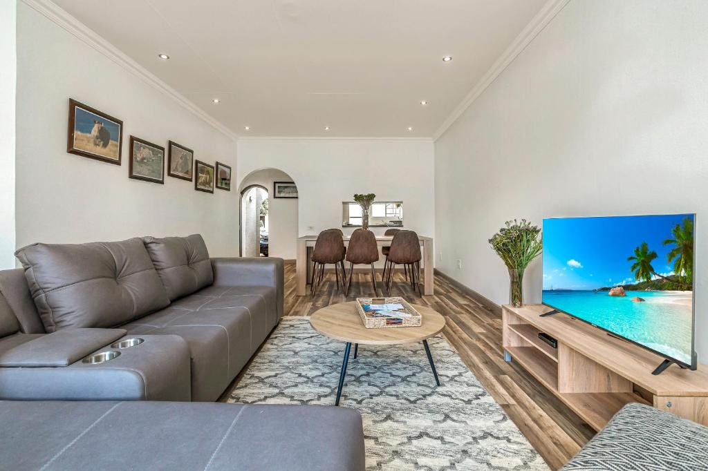 a living room with a couch and a large screen tv at Country Life Park in Johannesburg