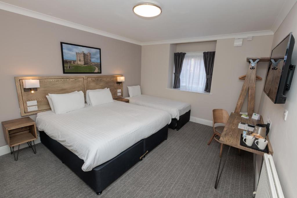 a hotel room with two beds and a television at Olde House, Chesterfield by Marston's Inns in Chesterfield