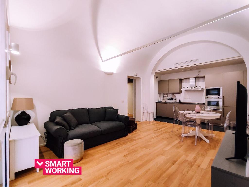uma sala de estar com um sofá preto e uma mesa em Appartamento elegante alle Due Torri by Wonderful Italy em Bolonha
