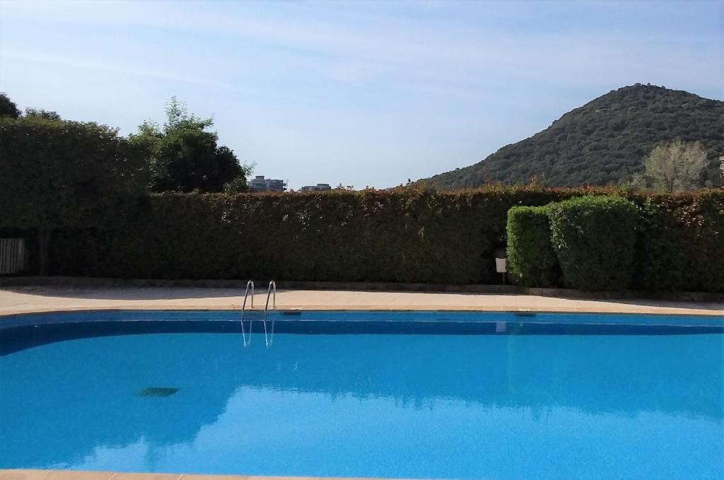 une piscine bleue avec une colline en arrière-plan dans l'établissement appartement entre golf, plages ,marina, à Mandelieu-la-Napoule