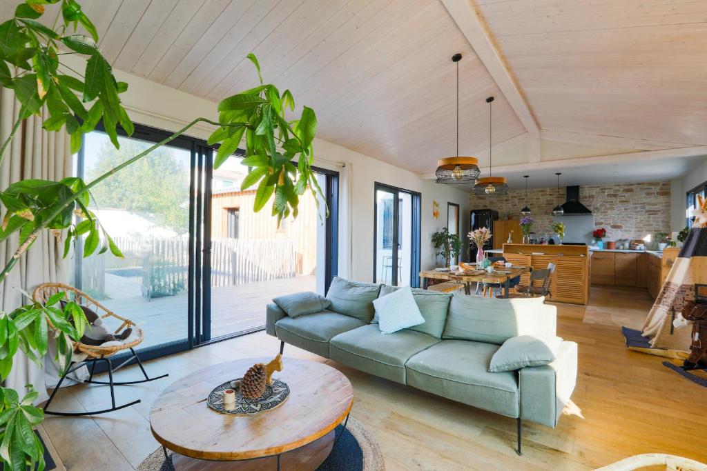 sala de estar con sofá y mesa en Entre mer et bois - Maison 6 personnes avec piscine - Le 7 en Rivedoux-Plage