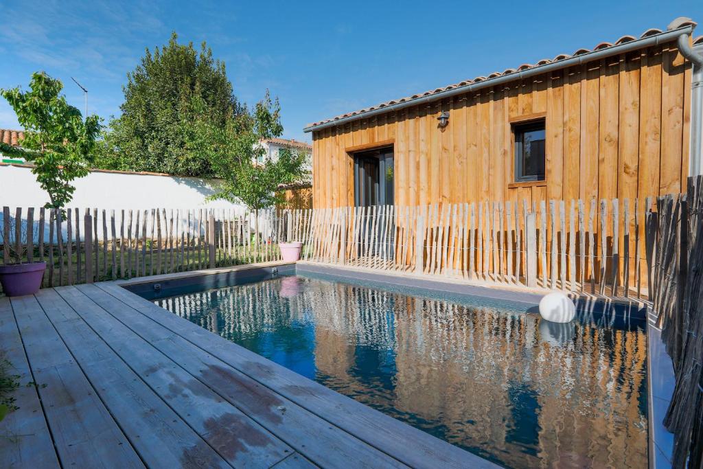 - une piscine en face d'une clôture en bois dans l'établissement Le 7 - Entre mer et bois - Maison avec piscine, à Rivedoux-Plage