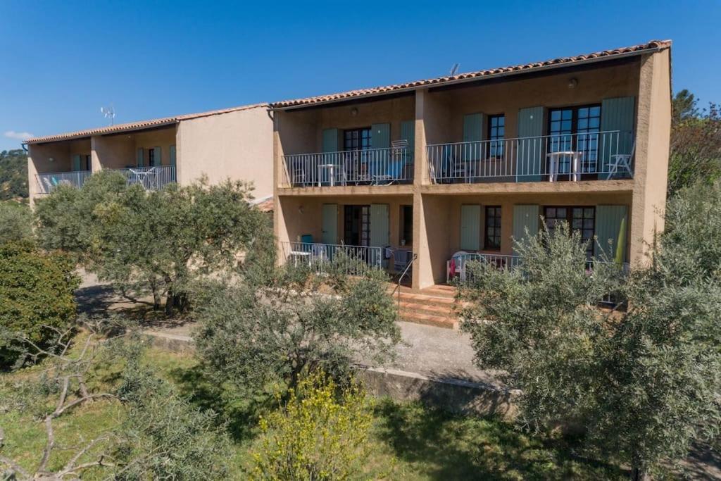 une maison sur une colline avec des arbres devant elle dans l'établissement Résidence Lou Cigaloun - ANA LOCATION, à Gréoux-les-Bains