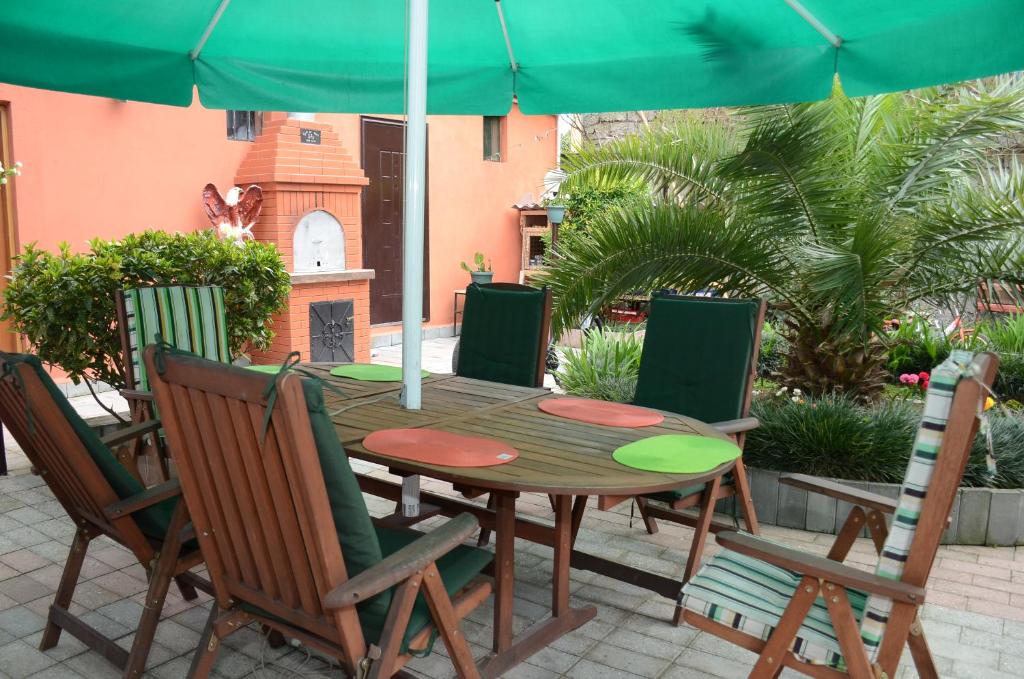 a wooden table and chairs with an umbrella at Nana's House in Batumi