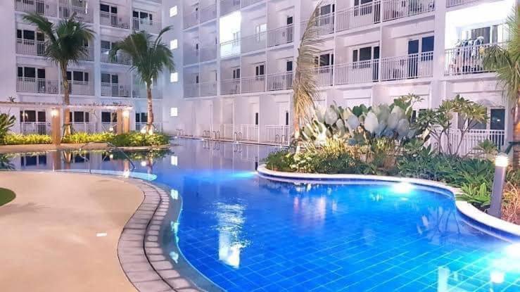 a large swimming pool in front of a building at Shore Residence D1,shortwalk MALL OF ASIA near airport wifi in Manila