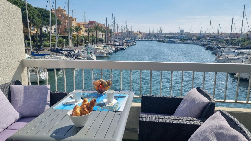 a table on a balcony with a view of a marina at Duplex sur Marinas Cap d'Agde in Cap d'Agde