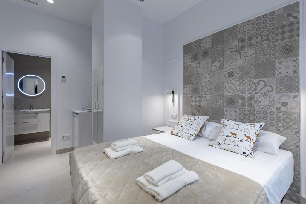 um quarto branco com uma cama grande e toalhas em Room close to City Centre em Valência