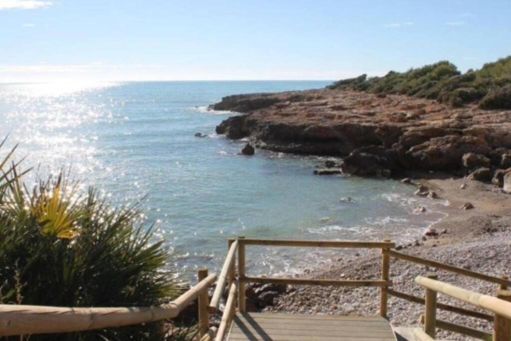 una escalera de madera que conduce a una playa con el océano en Peñiscola entre el Mar y las Montañas, en Castellón de la Plana