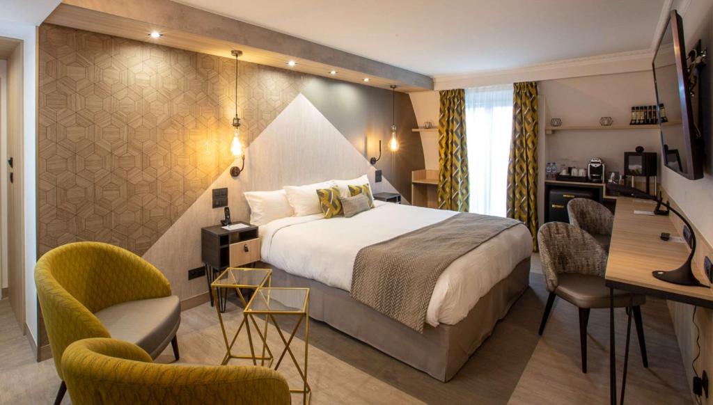 Habitación de hotel con cama, escritorio y sillas en Best Western Plus Opéra Batignolles, en París