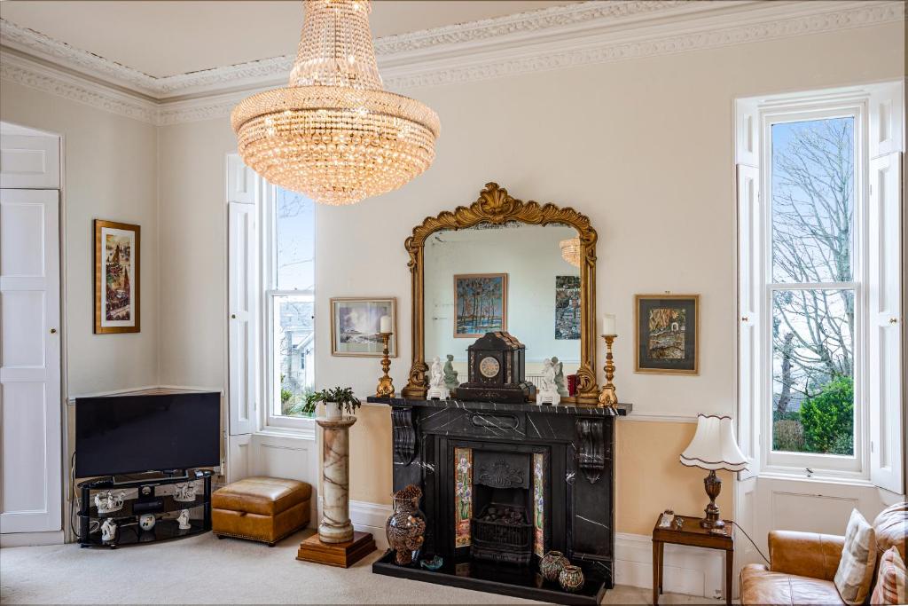 - un salon avec une cheminée et un miroir dans l'établissement Stunning Apartment in Victorian Villa with Garden, à Torquay