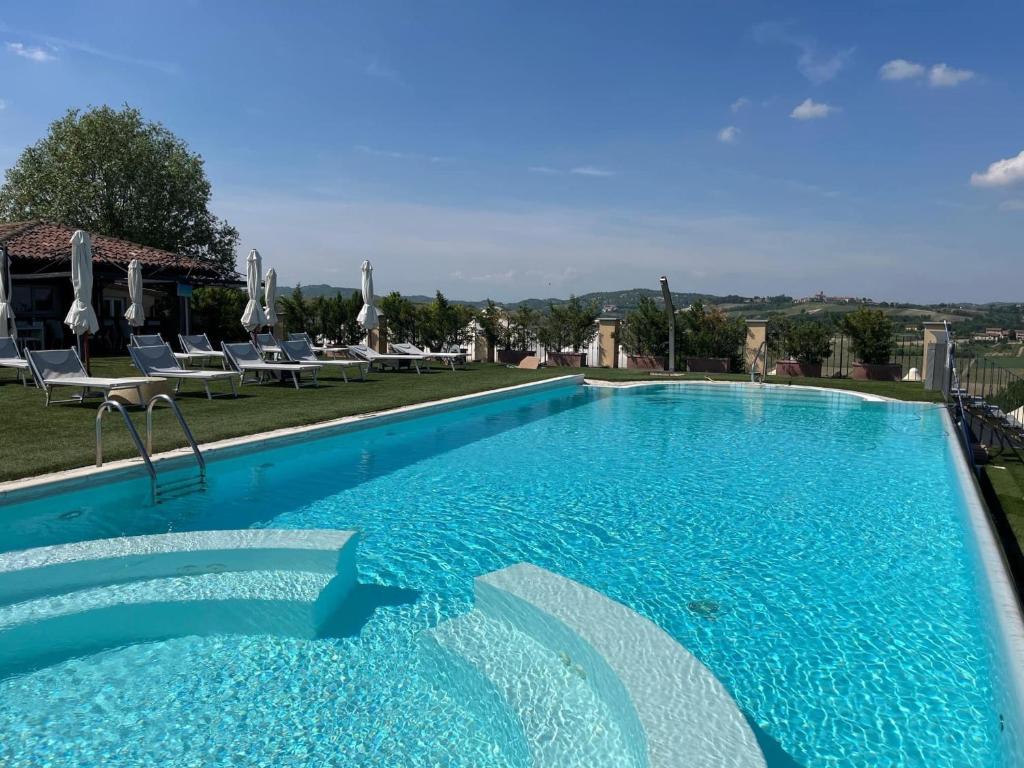 a large swimming pool with blue water at Villa Morneto in Vignale