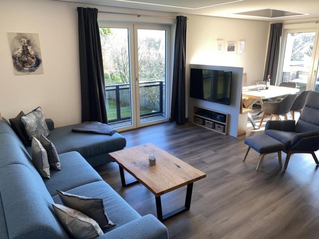 a living room with a couch and a tv and a table at Möwenblick - a57230 in Cuxhaven