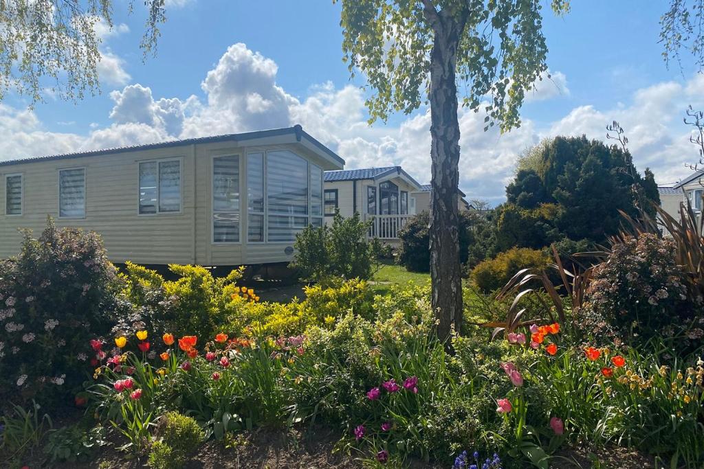 a garden with flowers in front of a house at Cleethorpes Pearl Holiday Park in Humberston