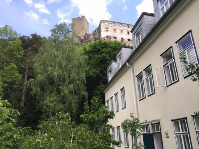 un edificio con un castillo en el fondo con árboles en Ruhige Wohnung in Helenental, en Baden