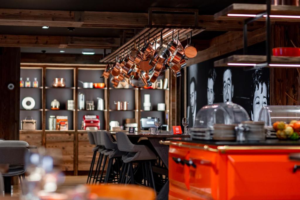 a bar in a restaurant with a counter and chairs at Hôtel Névé in Morzine