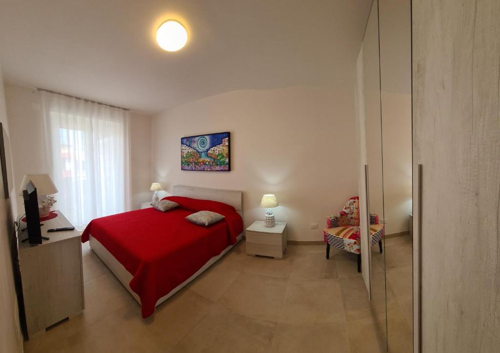 a bedroom with a red bed and a window at Kalypso in Polignano a Mare