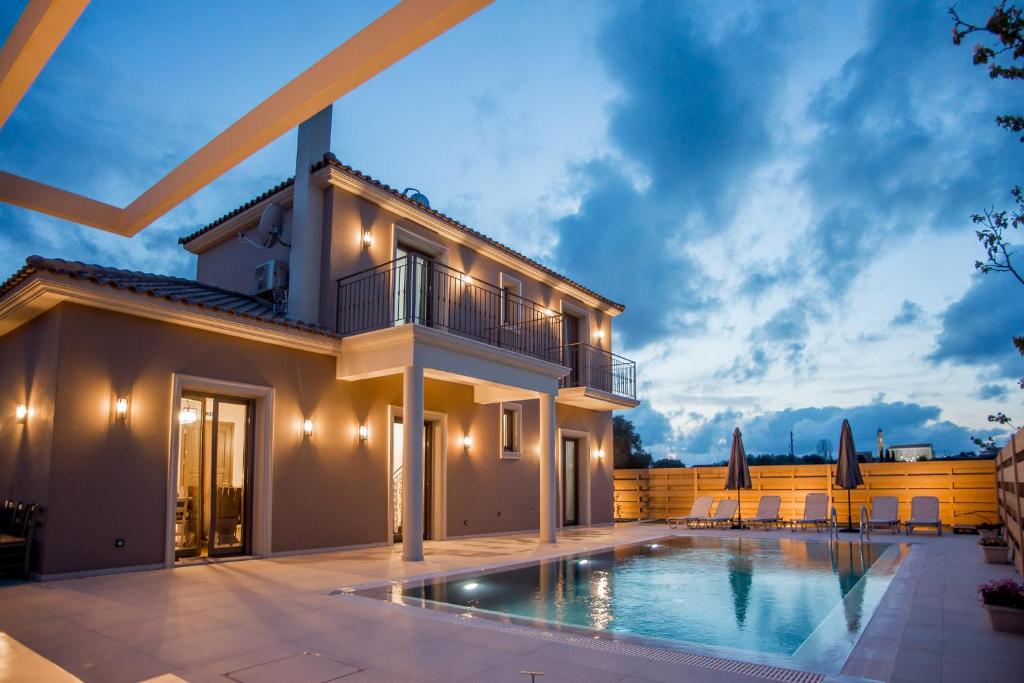a villa with a swimming pool and a house at Luxury Villa Chrisi in Svoronata