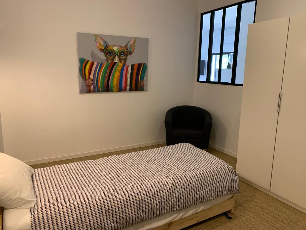 ein Schlafzimmer mit einem Bett und einem Gemälde eines Hundes in der Unterkunft Lovely place for 2-4 persons in Mollans-sur-Ouvèze