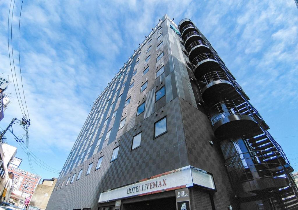 a tall building with a building with a funnel at HOTEL LiVEMAX Kokura Ekimae in Kitakyushu