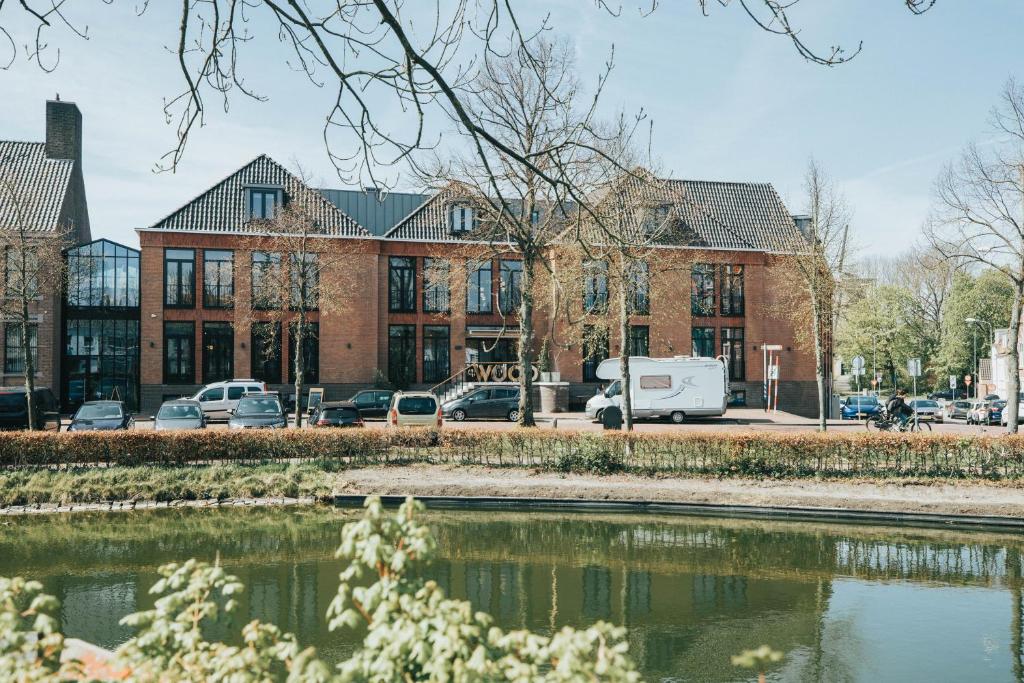 budynek z samochodami zaparkowanymi przed zbiornikiem wodnym w obiekcie Cityhotel Wood w mieście Middelburg
