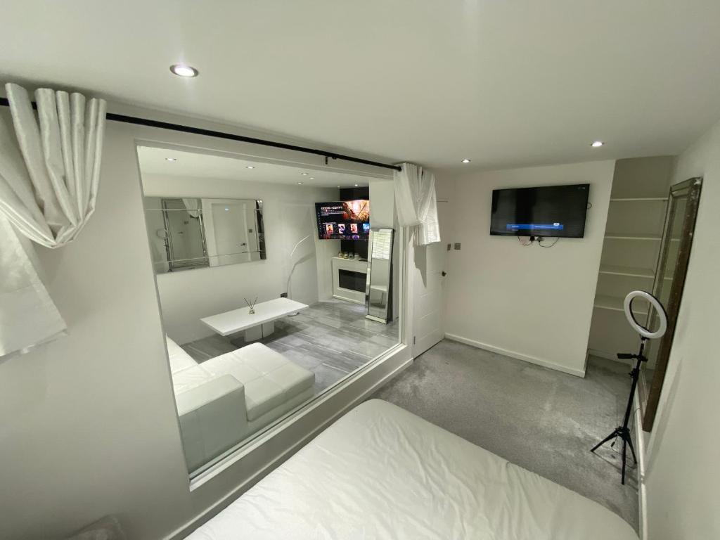a large white room with a view of a bathroom at Luxurious high spec 1 bedroom apartment in London in Eltham