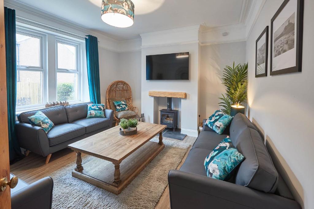 a living room with two couches and a table at Host & Stay - King's Cottage in Amble