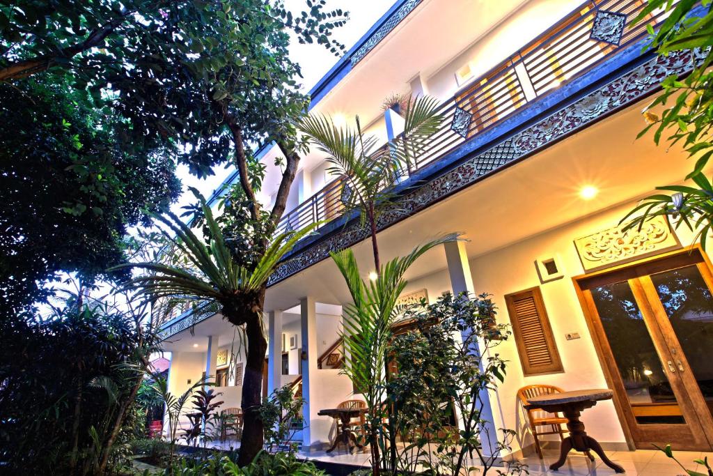 un edificio con palme di fronte ad esso di Batik Sekar Bali Guest House ad Ubud