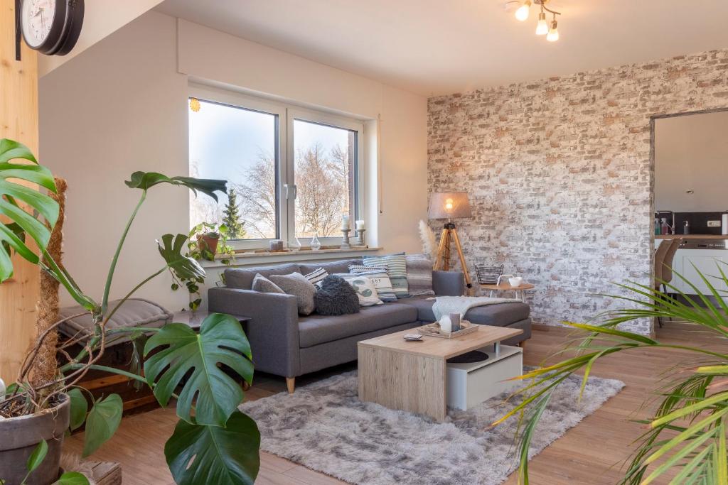 uma sala de estar com um sofá e uma mesa em Ferienwohnung Kathis Eifelblick em Simmerath