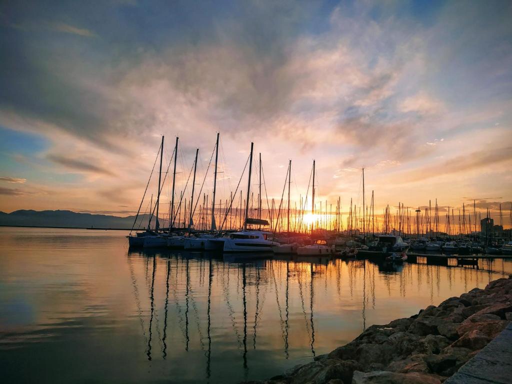 eine Gruppe von Booten, die bei Sonnenuntergang an einem Yachthafen angedockt sind in der Unterkunft Villa Marisa in Quartu SantʼElena