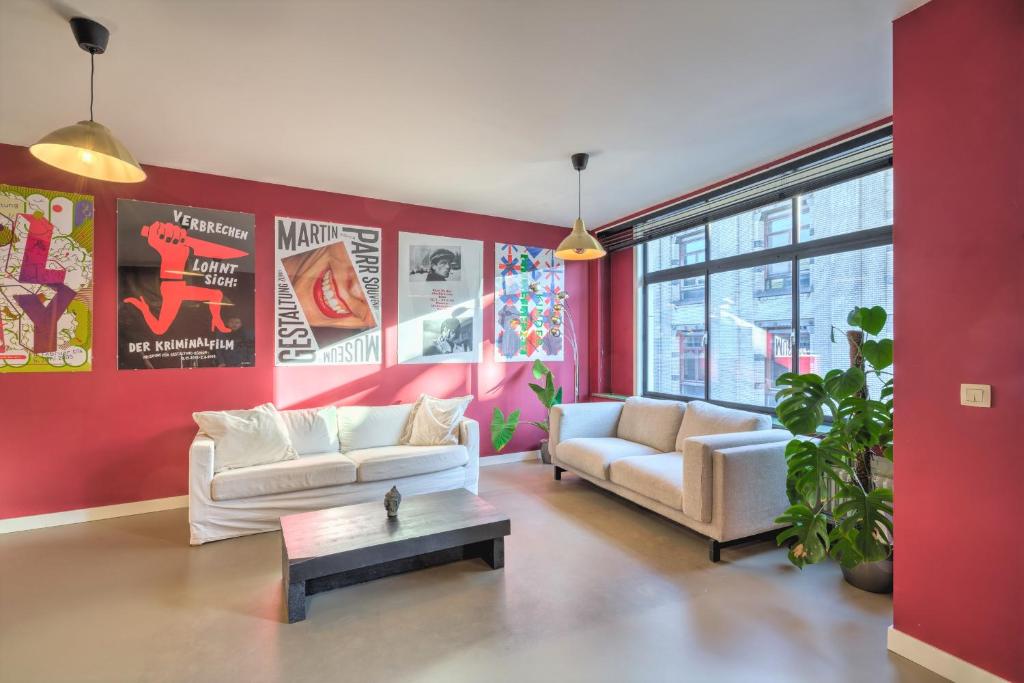 un soggiorno con 2 divani bianchi e una parete rossa di Spacious Apartments in the Heart of Antwerp ad Anversa