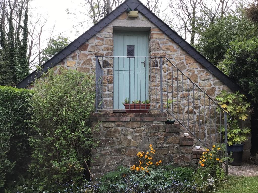 ein kleines Steinhaus mit blauer Tür und Treppe in der Unterkunft Lovely studio apartment near camborne in Camborne