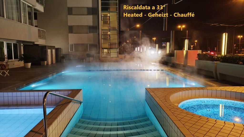 a large swimming pool with a hot tub in a building at Hotel Ascot & Spa in Rimini