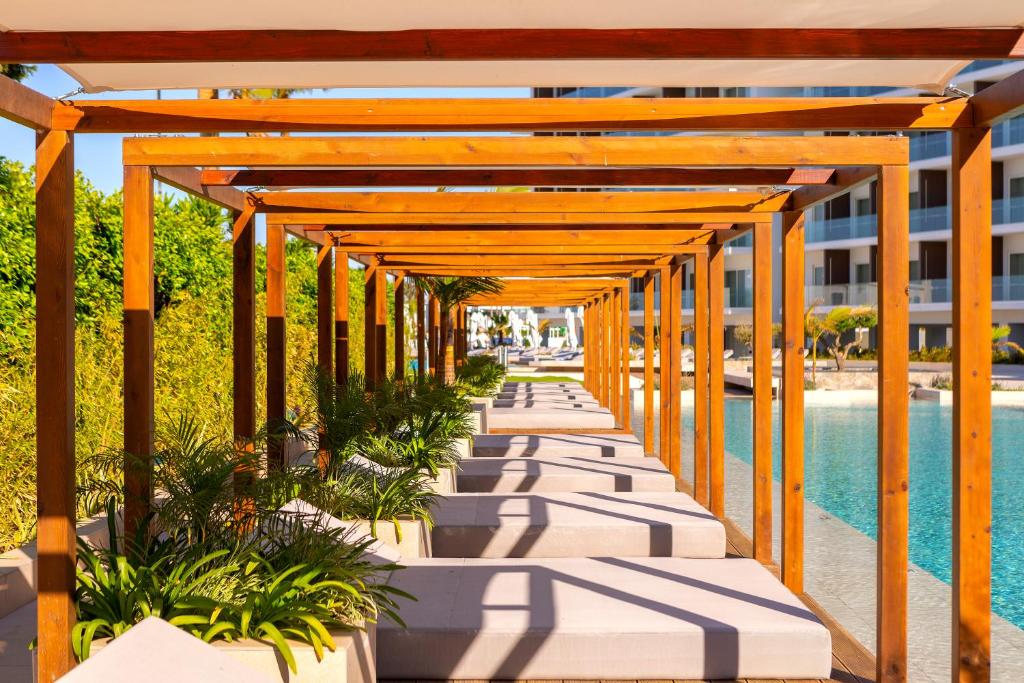 a wooden pergola over a pool at a resort at Chrysomare Beach Hotel & Resort in Ayia Napa