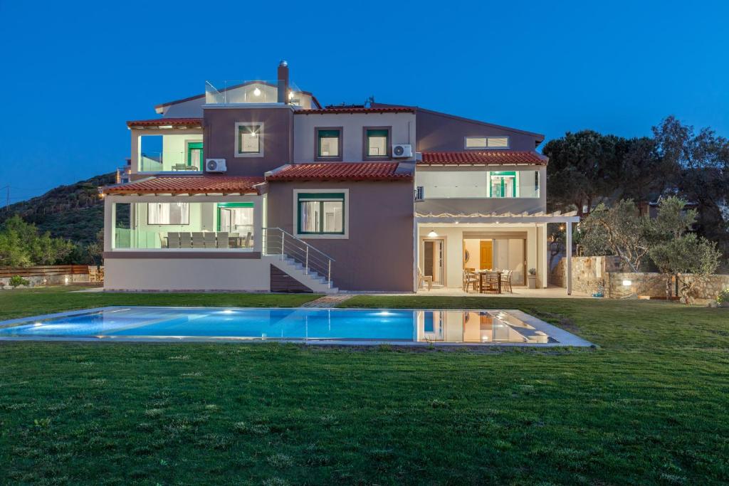 a house with a swimming pool in front of it at Villa Ourania in Agia Pelagia