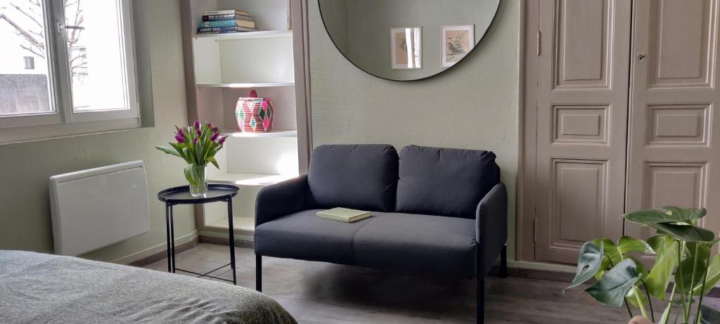 - une chambre avec une chaise bleue et un miroir dans l'établissement Bien agencé, cosy et calme, joli petit appart!, à Tours