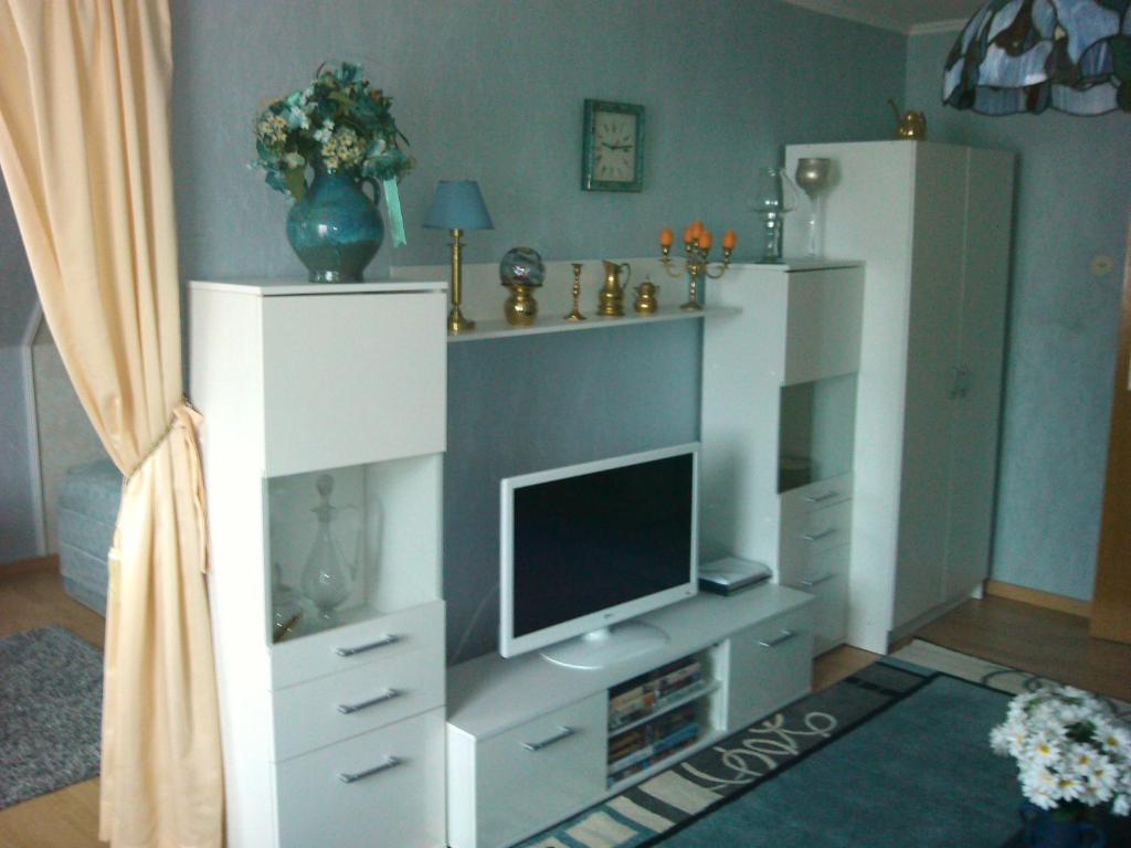 a living room with a white entertainment center with a television at Sonnendeich in Norddeich