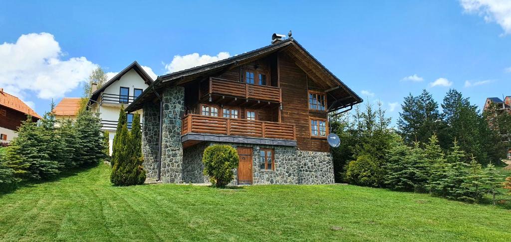 una casa en una colina con un patio verde en Pine Valley House, en Zlatibor