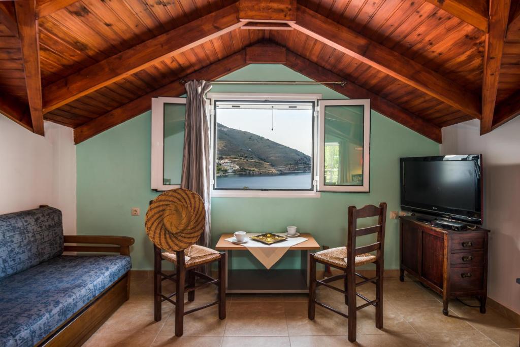 een kamer met een bed, een tafel en een raam bij MAKRIS HOUSE in Ayia Evfimia
