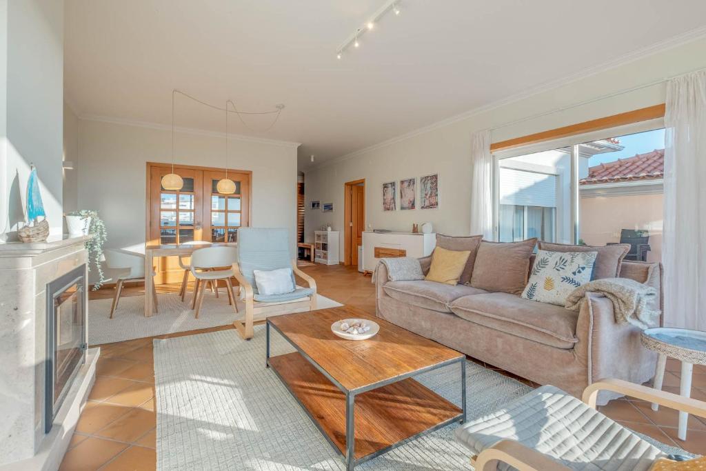 a living room with a couch and a table at Stunning Sea View Apartment Praia D'El Rey in Casal da Lagoa Seca