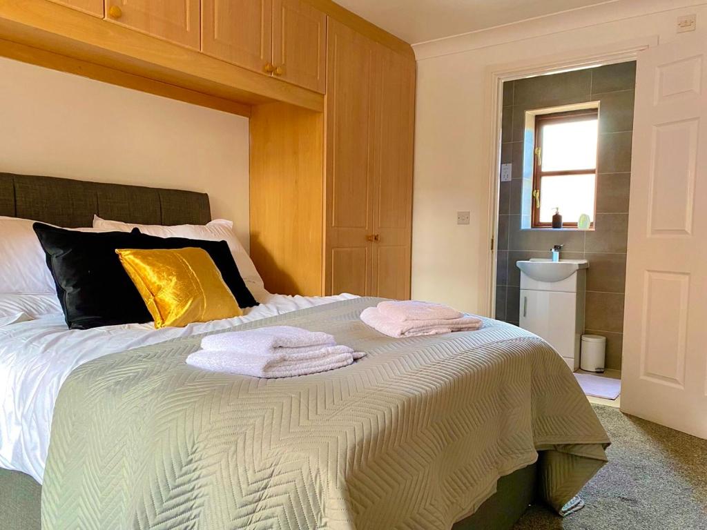 a bedroom with a bed with towels on it at Spacious 3 Bedroom Contractor Home with Private Parking, Just 7 Minutes from CMK by Maison 19 in Calverton