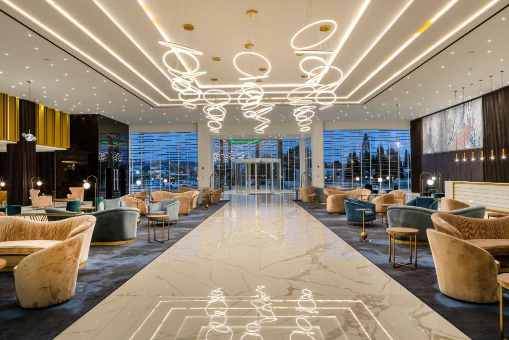 a lobby with couches and chairs and a chandelier at Chrysomare Beach Hotel & Resort in Ayia Napa