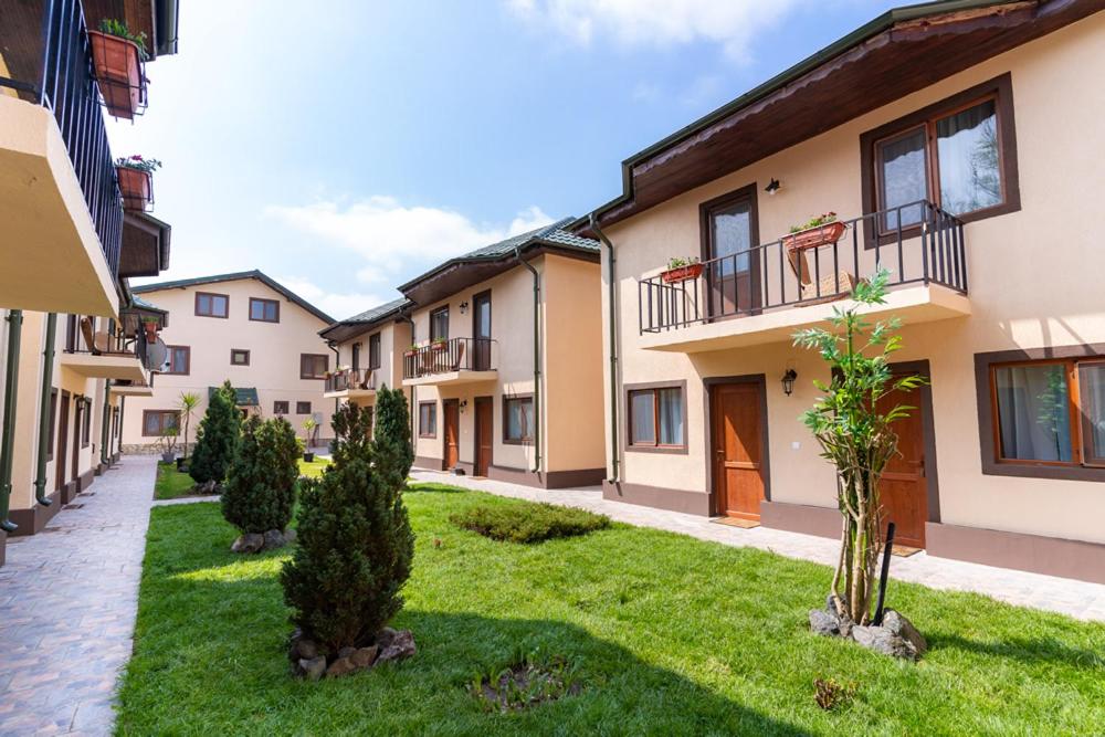 a row of apartment buildings with trees in a yard at Complex Lotus in Crisan