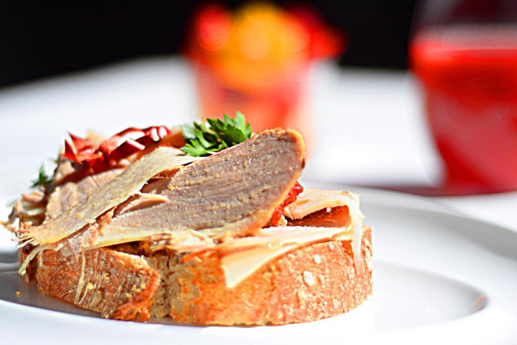 a sandwich on a white plate on a table at Hotel Adonis Plaza in Santa Cruz de Tenerife