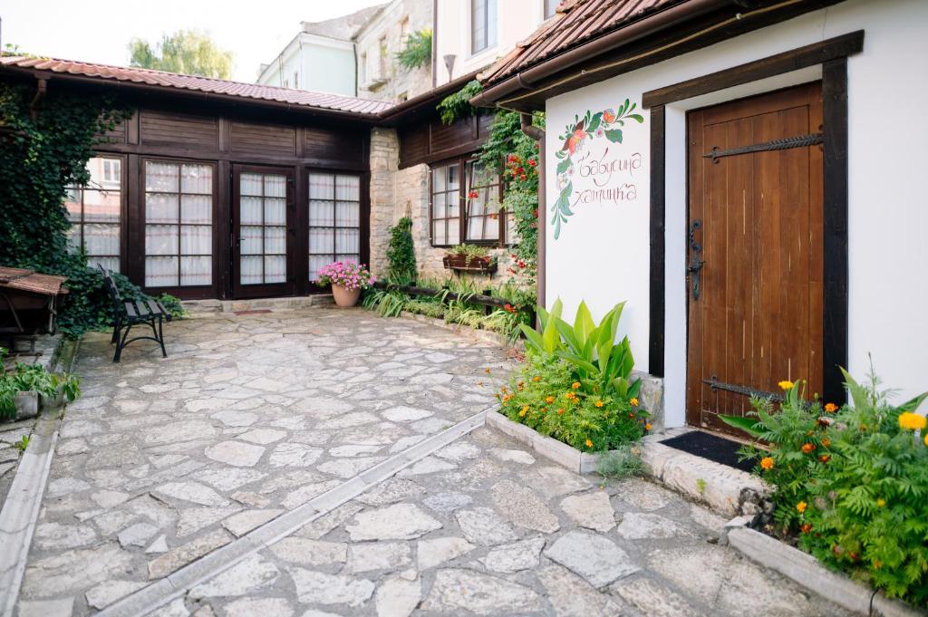 a patio in front of a house with a wooden door at Hetman Hotel in Kamianets-Podilskyi