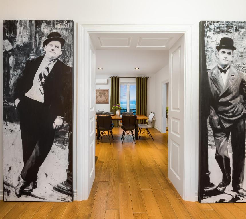 een hal met twee ingelijste portretten van mannen op de muren bij Charlie Chaplin in Split