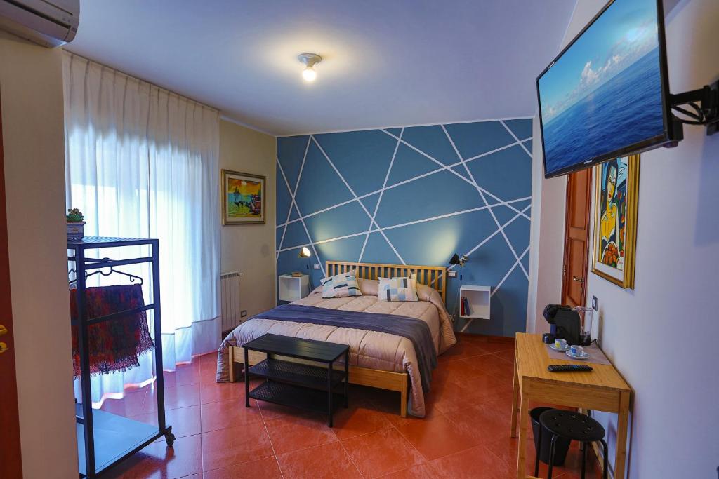 a bedroom with a bed and a flat screen tv at B&B CasaBuddace in Messina