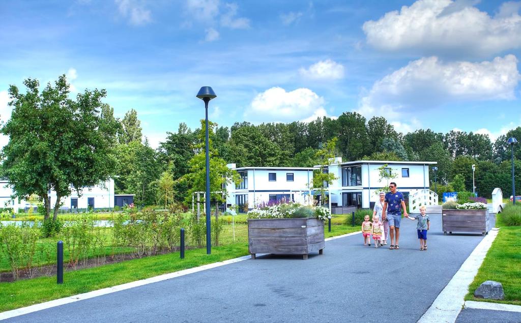 een man en twee kinderen die over straat lopen bij EuroParcs Bad Hulckesteijn in Nijkerk