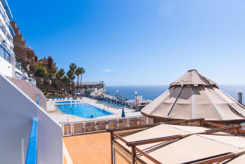 une piscine sur le côté d'un navire de croisière avec des parasols dans l'établissement Home2Book Valle de Taurito, Sea Views & Pool, à Taurito