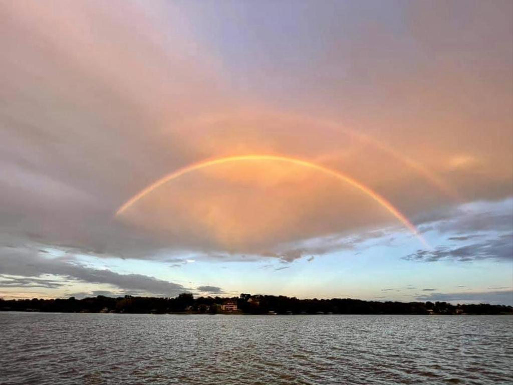 een regenboog in de lucht boven een lichaam van water bij Lake Home by Nashville- Hot tub, swim, fish in Hendersonville